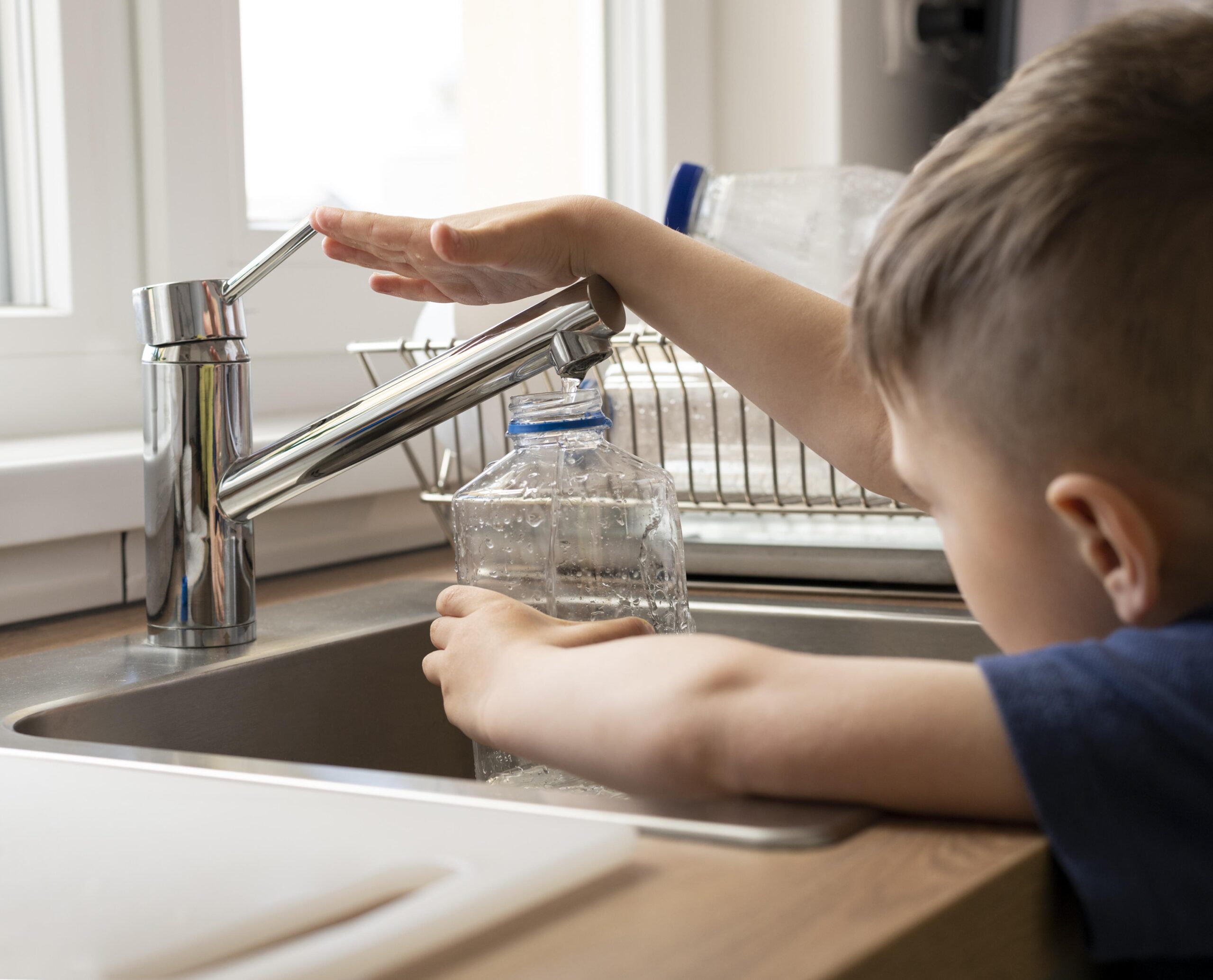 close up kid filling bottle with water scaled В Краснослободске построили станцию водоочистки