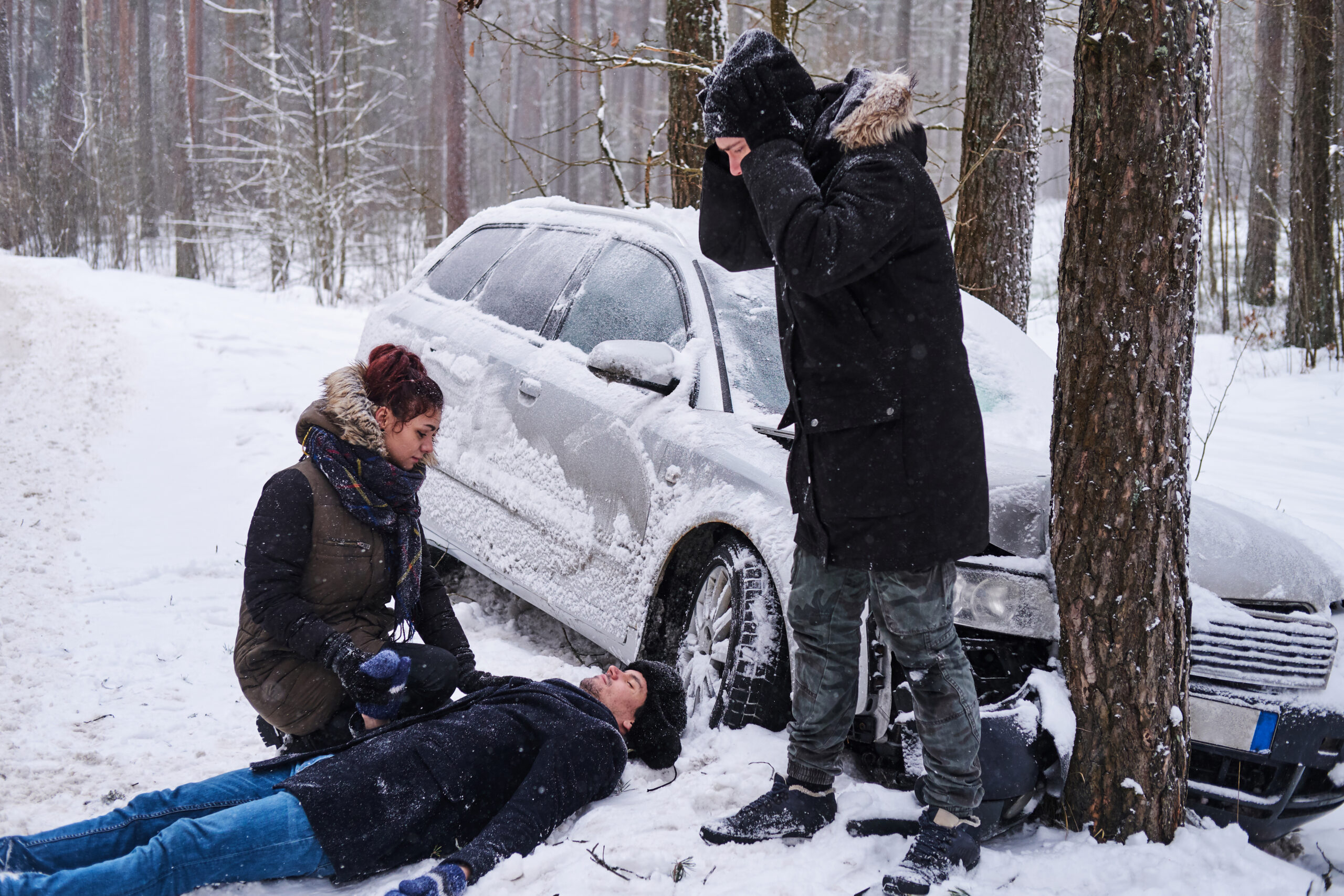 after car crush winter forest injured man is lying snow woman is trying help him another man is despair scaled Смертельное ДТП произошло  с участием министра культуры Мордовии