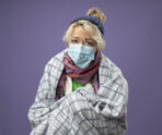 sick unhealthy woman with short hair warm hat scarf wearing protective facial maskwrapped blanket feeling unwell looking camera unhappyover purple background В Мордовии наблюдается рост заболеваемости ОРВИ
